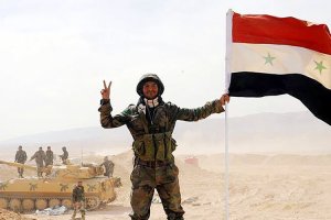 Um soldado do Exército Árabe Sírio faz o sinal da vitória em Deir ez-Zor