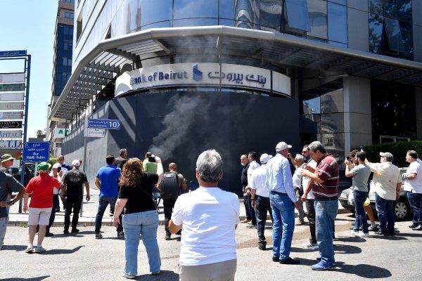 <p>Manifestação de depositantes libaneses que continuam sem poder levantar as suas poupanças em moeda estrangeira. Os clientes bancários, na sua maioria impedidos de aceder às suas contas em moeda estrangeira na sequência da crise financeira de 2019, reuniram-se na Praça dos Mártires antes de marcharem em direcção ao subúrbio de Sin el-Fil, a leste de Beirute, onde várias fachadas de bancos foram vandalizadas. Beirute, Líbano, 28 de Julho de 2026</p>