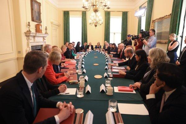 <p>O novo primeiro-ministro britânico, Andy Burnham, com os ministros durante a sua primeira reunião de Conselho de Ministros, no n.º 10 de Downing Street, em Londres, Grã-Bretanha. O Reino Unido vai eliminar um imposto de 5% sobre as faturas de energia a partir de outubro, anunciou Burnham, a primeira de várias medidas que se espera que proporcionem às famílias mais «margem de manobra» face ao custo de vida. 21 de julho de 2026.</p>