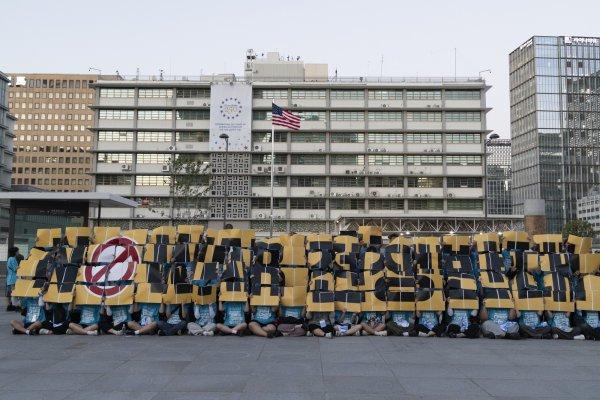<p>Membros do Grupo de Acção Estudantil Universitário pela Paz e Autonomia erguem cartazes com a mensagem «Stop War» durante uma manifestação perto da embaixada dos EUA em Seul. Os manifestantes reuniram-se para protestar contra a política de defesa do presidente dos EUA, Trump, em relação à Coreia do Sul. 11 de Agosto de 2026</p>