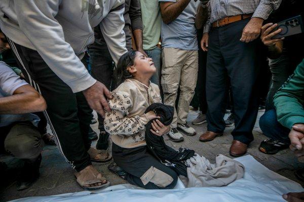 <p>Dima, de dez anos, filha de Akram Yassin e Dena Abu Baker, chora junto aos corpos dos pais no Hospital Al-Shifa, durante o funeral realizado em Gaza. De acordo com um relatório do ministério da Saúde de Gaza, os pais de Dima foram mortos num ataque aéreo israelita na zona oeste da cidade. 20 de Outubro de 2026</p>