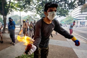 Manifestante prepara-se para lançar um cocktail Molotov contra a polícia durante o protesto promovido pela direita venezuela, em Caracas. 19 de Abril de 2017