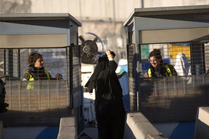 Uma palestiniana mostra a sua cara para passar pelo posto de controlo israelita de Qalandia, em Jerusalém. Palestina, 23 de Junho de 2017.