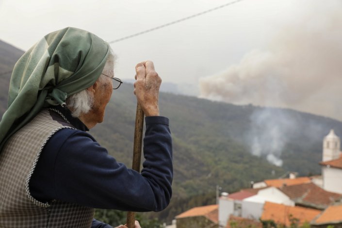 Uma residente observa um incêndio florestal na Serra do Açor, Arganil, Centro de Portugal, 16 de Outubro de 2017.