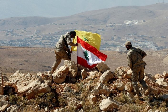 Combatentes do Hezbollah colocam bandeiras do movimento de resistência e do Líbano em Yarud Arsal, em Agosto de 2017, depois da vitória sobre o Daesh