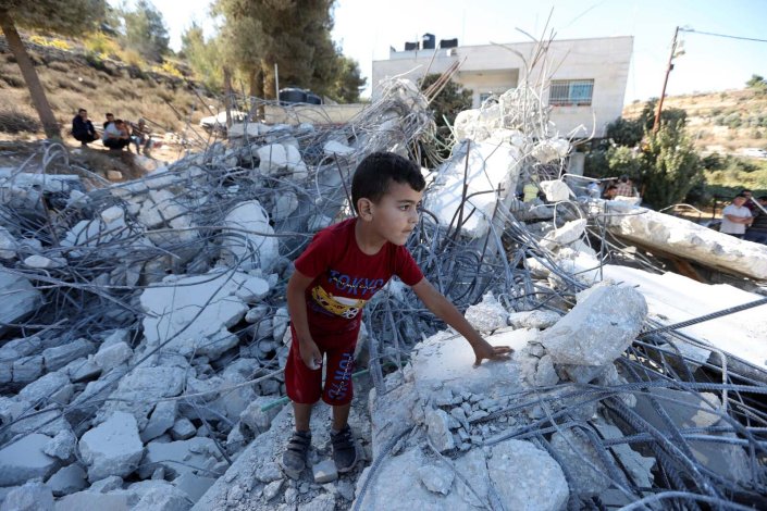 Criança palestiniana sobre os escombros de um prédio demolido pelo Exército israelita. 3 de Outubro de 2019, Beit Ummar, Cisjordânia ocupada, Palestina