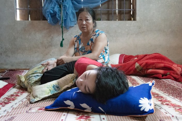 A vietnamita Nguyen Thi Thuy, nascida em 1961, cuida do seu filho Tran Thi Hong desde que este nasceu, paralisado, em 1993. São duas das mais de três milhões de vítimas, distribuídas por quatro gerações, do agente laranja, desfolhante lançado pelas tropas norte-americanas durante a Guerra do Vietname, entre 1955 e 1975.