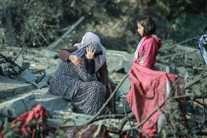 Mulher palestiniana sentada nos escombros de casas atingidas por ataques aéreos israelitas em Khan Younis, na Faixa de Gaza, a 13 Novembro de 2019