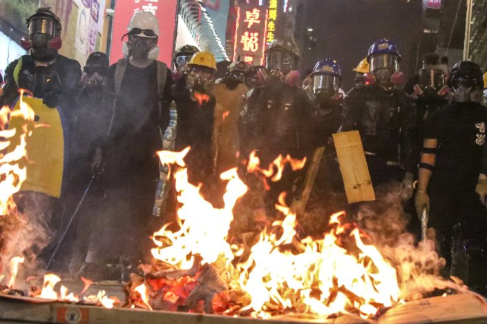 Manifestantes contra a lei da extradição deitam fogo a objectos, para obstruir a rua Nathan, em Mong Kok, Hong Kong, a 3 de Agosto de 2019