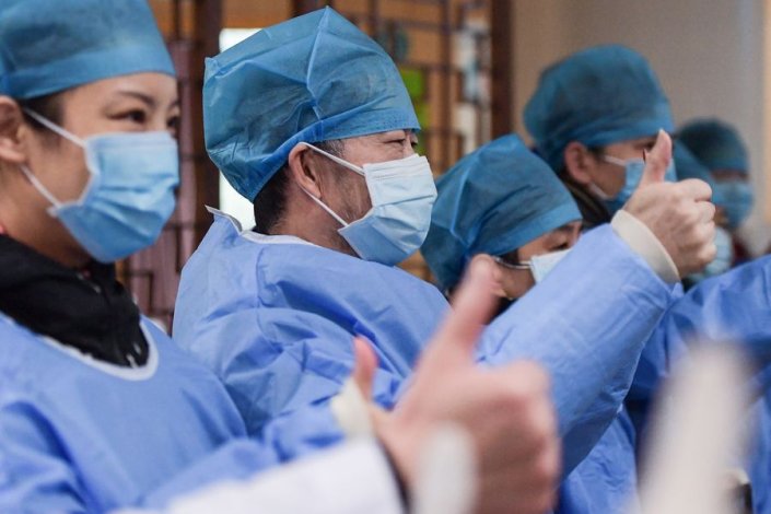 Um grupo de doentes que estiveram infectados com o coronavírus e recuperaram festeja num hospital em Wuhan, na província chinesa de Hubei (6 de Fevereiro de 2019)