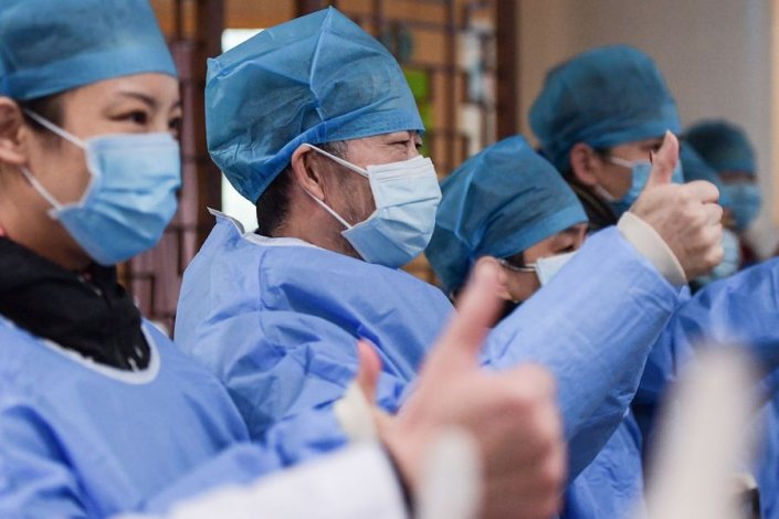 Un groupe de patients infectés par le coronavirus et guéris fêtent dans un hôpital de Wuhan, dans la province chinoise du Hubei (6 février) 