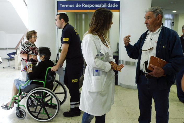 Uma médica do Hospital de Santa Maria conversa com um utente no primeiro dia de greve nacional de médicos contra a degradação do SNS, em Lisboa, 11 de julho de 2012. Foto de arquivo