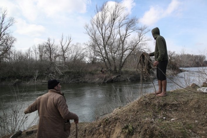 Um refugiado nada de volta para o lado turco depois de ficar preso por dois dias numa pequena ilha no rio Meric (Evros) para chegar à Europa, na fronteira turco-grega, em Edirne, Turquia, 1 Março de 2020. O governo turco anunciou a decisão de não continuar a impedir os refugiados de atravessarem a fronteira, depois de vários soldados turcos terem morrido em Idlib, na Síria, a 27 de Fevereiro, por se encontrarem entre fileiras terroristas.
