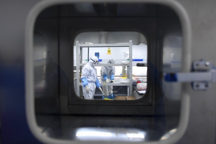 Trabalhadores de um laboratório de detecção do coronavírus COVID-19, em Wuhan, na província de Hubei, China, a 22 de Fevereiro de 2020 