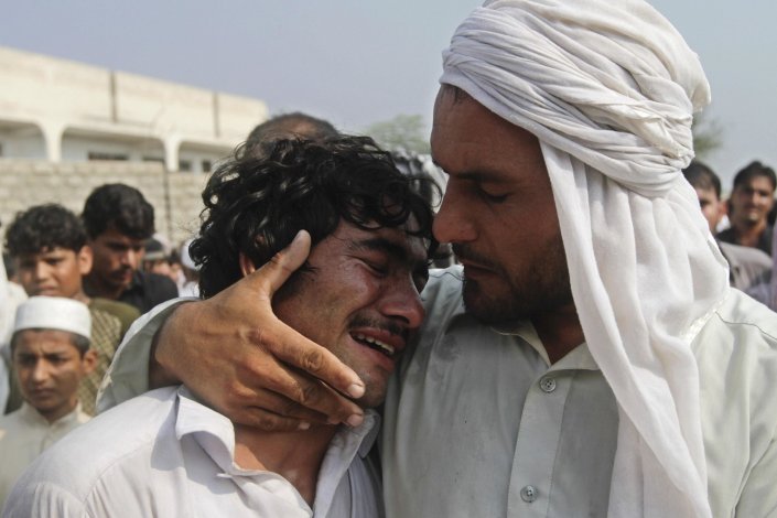 Um afegão chora o seu irmão, morto num ataque aéreo da NATO, na província de Jalalabad, Afeganistão, a 5 de Outubro de 2013. Pelo menos cinco civis foram mortos durante esse ataque, acusou o porta-voz do governo provincial afegão. A intervenção militar da coligação militar liderada pelos EUA foi acusada de causar um número desproporcionadamente alto de baixas civis 