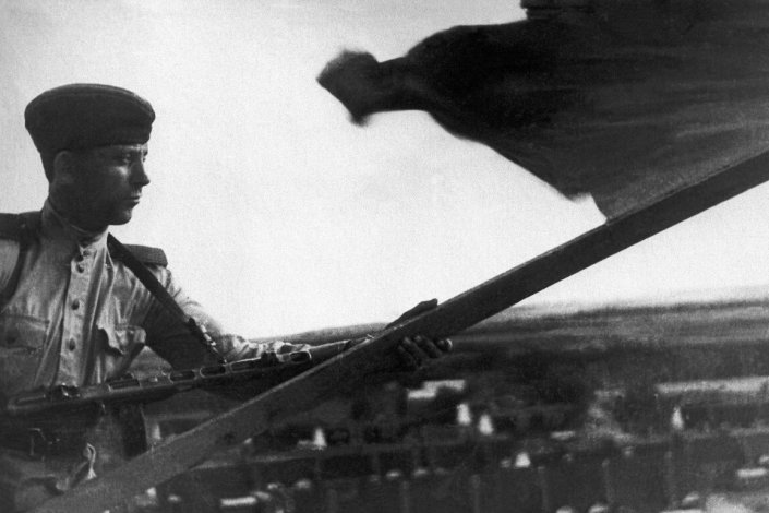 Um soldado do Exército Vermelho coloca a bandeira da URSS no telhado de um edifício, numa localidade da Sacalina do Sul (Japão, 1945). Foto do Museu de História do Extremo Oriente VK Arsenev