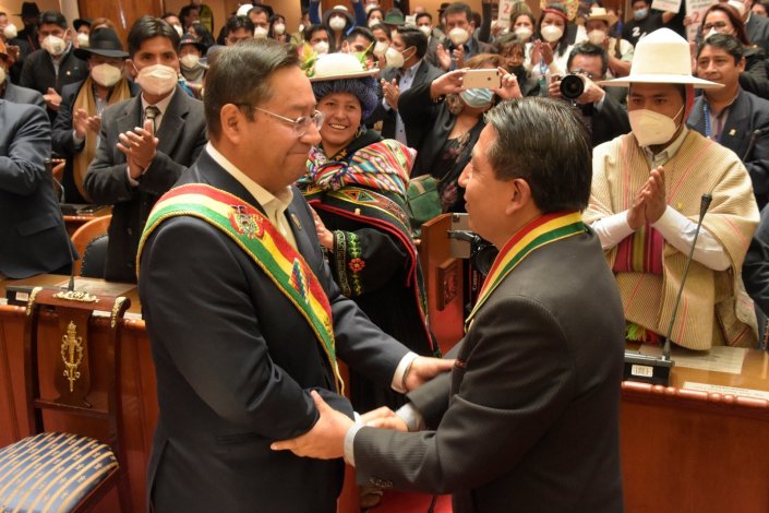 O presidente da Assembleia Legislativa, David Choquehuanca, entrega a faixa presidencial a Luis Arce, durante a tomada de posse deste como Presidente da República, em La Paz, Bolívia, a 8 de Novembro de 2020. A democracia regressa ao país após um ano de interregno em que o cargo foi ocupado por uma presidente «de facto» Jeanine Áñez, na sequência do golpe de Estado antipopular de Novembro de 2019