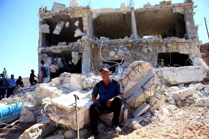 Palestinianos junto a edifício demolido pelas forças israelitas em Hebron/al-Khalil (imagem de arquivo)