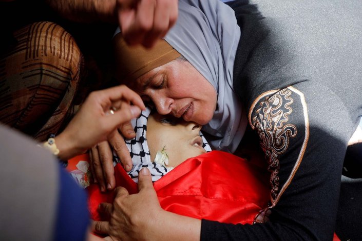 A mãe do jovem palestiniano Rasheed Abu Arra, morto por tropas israelitas, chora o seu filho, durante o funeral realizado em Aqqaba, perto de Tubas, na Cisjordânia ocupada por Israel, a 13 de Maio de 2021 