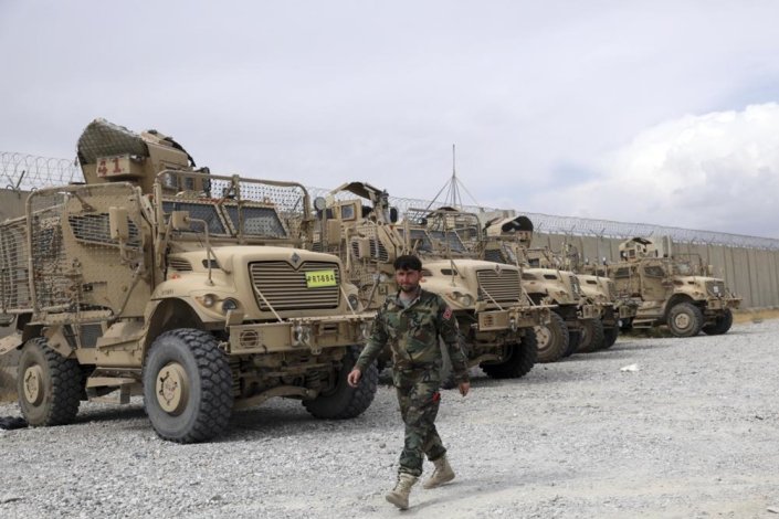 Soldado afegão junto de blindados abandonados pelas tropas dos EUA após estas abandonarem a base de Bagram. Afeganistão, 5 de Julho de 2021
