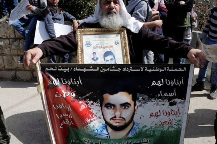 Um palestiniano participa num protesto para exigir a libertação do corpo do seu filho morto pelas forças israelitas
