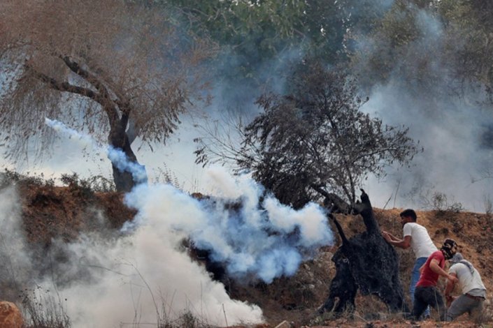 Manifestantes palestinianos repelem latas de gás lacrimogéneo disparadas por forças israelitas durante os confrontos que se seguiram à manifestação contra o colonato de Eviatar, na localidade de Beita, no Norte da Cisjordânia ocupada, a 27 de Agosto de 2021