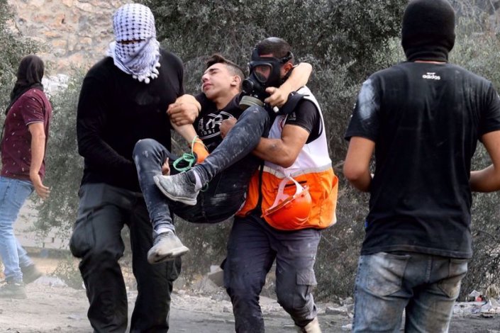 Um paramédico e um outro homem levam um rapaz palestiniano do local dos confrontos entre palestinianos e tropas israelitas, depois de uma manifestação na localidade de Beita, província de Nablus, na Margem Ocidental ocupada, no dia 10 de Setembro de 2021