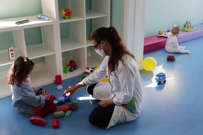 Criança e educadora, esta usando máscara protectora, brincam em creche do Porto, a 18 de Maio de 2020