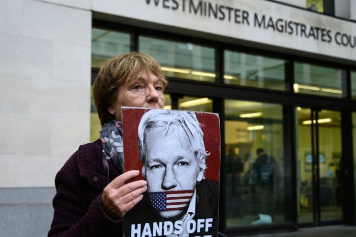 Uma defensora de Julian Assange segura um cartaz em sua defesa e contra a extradição, junto ao Tribunal de Westminster, em Londres 