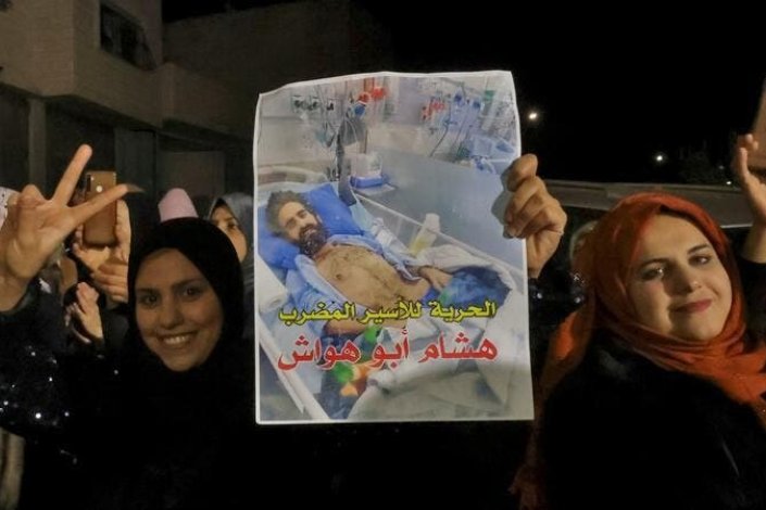 Palestinianos fazem o sinal da vitória junto à casa de Hisham Abu Hawwash, em Dura (Cisjordânia ocupada), depois de saberem do acordo alcançado e do fim da greve de fome