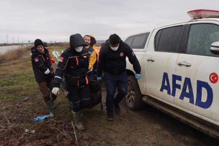 Membros da equipa de Desastres e Emergências da Turquia transportam o corpo de um dos migrantes encontrados na ladeia de Paşaköy, junto à fronteira com a Grécia  
