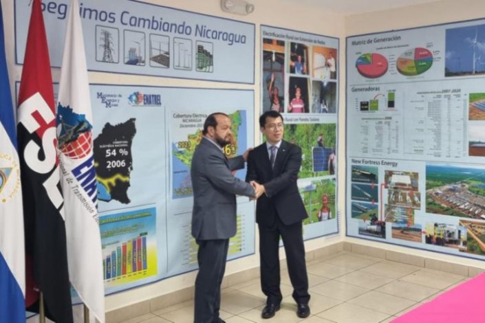 Representante chinês e da empresa estatal nicaraguense das águas, ENACAL, saúdam-se durante a celebração do acordo