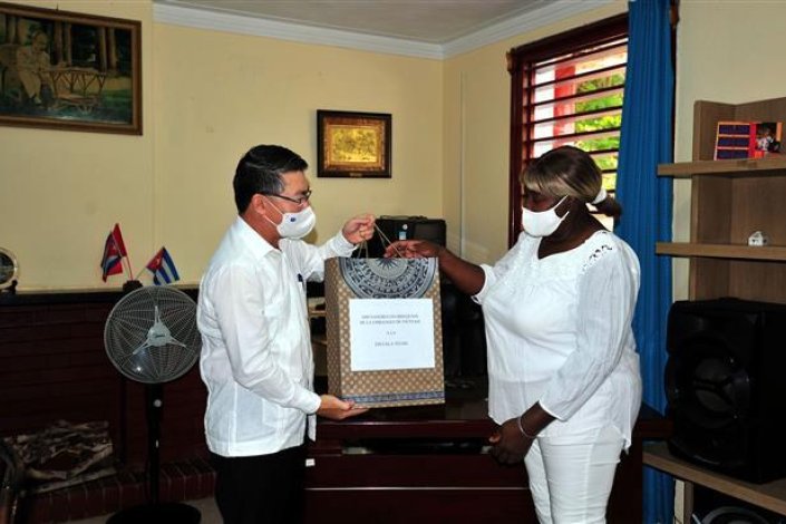 O embaixador voetnamita em Cuba, Le Thanh Tung, oferece presentes à directora da escola primária Ho Chi Minh em Havana, Milagros Negret Calderí / VNA