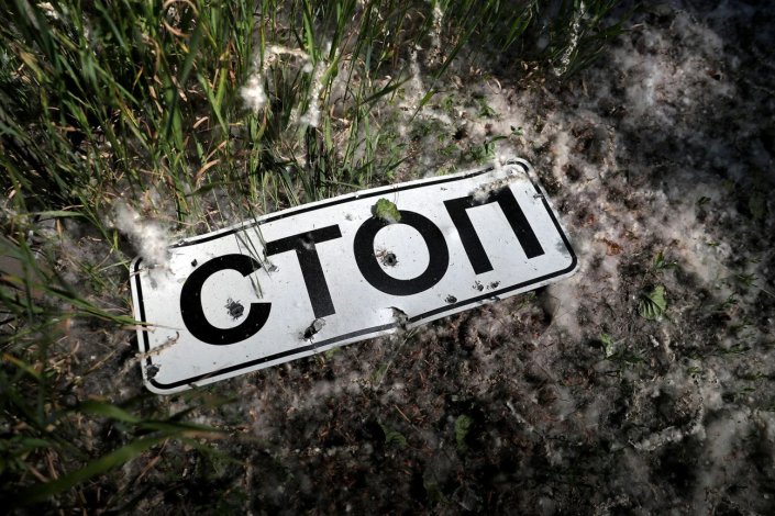«Stop». Sinal rodoviário avisando da necessidade de parar danificado por um bombardeamento nos arredores de Kharkiv, Ucrânia, a 10 de Junho de 2022