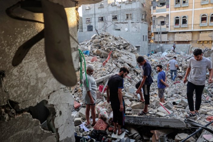 Palestinianos inspeccionam um edifício residencial atingido pela aviação israelita, em Rafah, no Sul da Faixa de Gaza, a 6 de Agosto de 2022