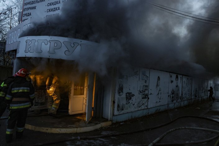 Bombeiros extinguem um incêndio numa loja de brinquedos atingida por bombardeamentos do exército ucraniano, em Donetsk, na autoproclamada República Popular de Donetsk, a 11 de Dezembro de 2022. Os sucessivos ataques de mísseis e artilharia que atingiram as zonas residenciais e comerciais da cidade causaram pelo menos 11 mortos e 25 feridos entre a população civil.