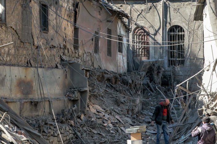 Grupo de pessoas inspecciona edifício atingido no ataque israelita com mísseis, na madrugada de domingo, 19 de Fevereiro de 2023