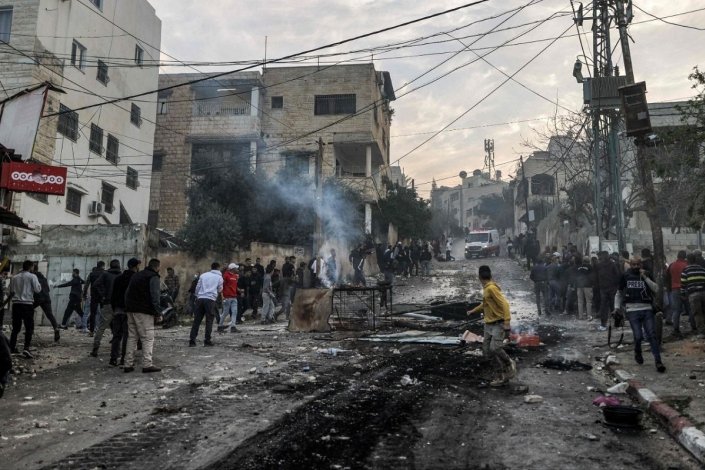Jovens palestinianos juntam-se durante a incursão israelita no campo de refugiados de Jenin, a 7 de Março de 2023
