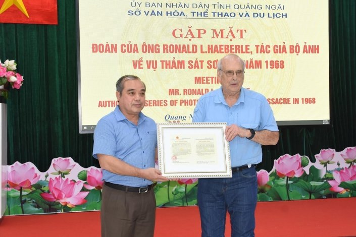 Um dirigente da província de Quang Ngai oferece uma carta de agradecimento a Robert L. Haeberle, que fotografou o Massacre de Son My