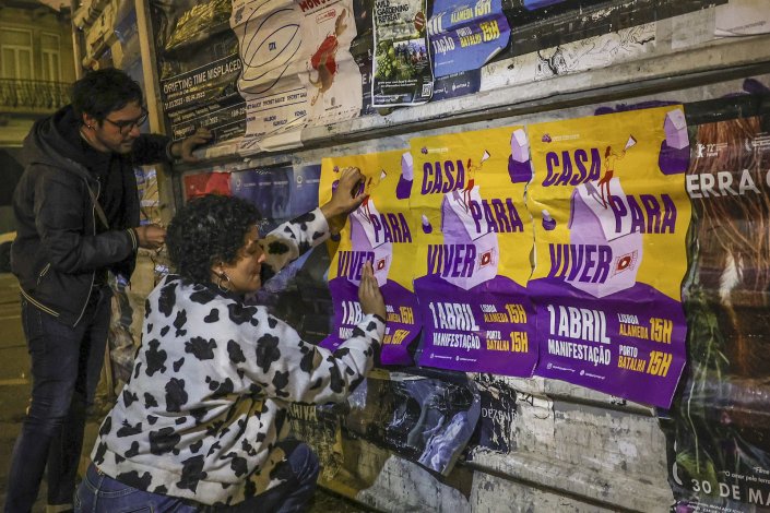 Activistas colam cartazes da manifestação de 1 de Abril nas ruas de Lisboa.