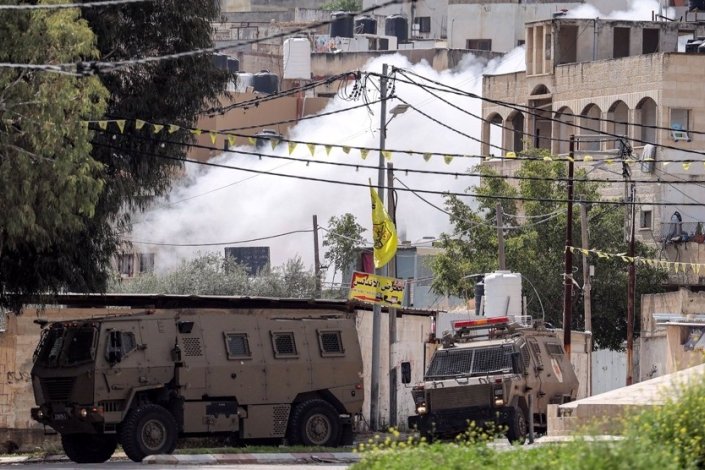 Uma coluna de fumo branco ergue-se no ar durante os confrontos entre elementos da resistência palestiniana e tropas israelitas, num raide levado a cabo pelas forças de ocupação em Jenin, no Norte da Cisjordânia, a 19 de Junho de 2023