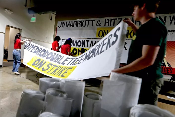 Trabalhadores da Hotelaria e dirigentes sindicais preparam faixas para a greve na sede do sindicato Unite Here Local 11, em Los Angeles