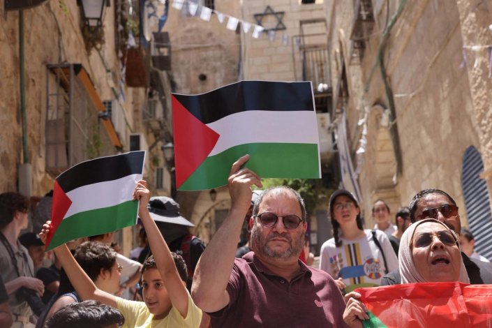 Ofer Cassif, deputado do Partido Comunista de Israel, eleito na coligação Hadash, segura uma bandeira da Palestina durante uma manifestação contra o despejo de uma família palestiniana na Cidade Velha de Jerusalém. 16 de Junho de 2023