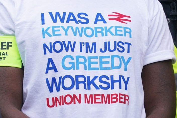 Maquinistas num piquete de greve, em Londres, a 24 de Janeiro de 2024; na T-shirt lê-se: «Eu era um trabalhador-chave, agora sou apenas um sindicalista ganancioso e preguiçoso»
