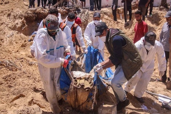 Elementos da protecção civil em Gaza retiram corpos de uma enorme vala comum do Hospital Nasser, em Khan Younis, a 21 de Abril de 2024. Até ao momento foram encontrados 283 corpos, entre os quais, afirmam, se encontram pacientes, pessoal médico e refugiados, alguns com marcas de tortura e execução