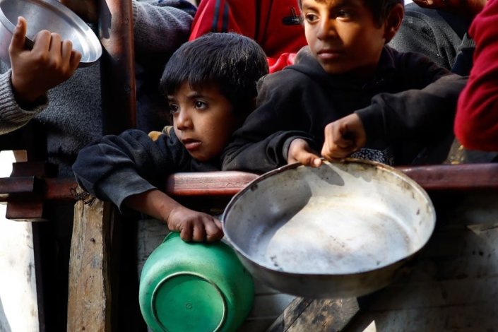 Crainaças palestinianas à espera de receber comida em Rafah, no Sul da Faixa de Gaza, em Janeiro de 2024 