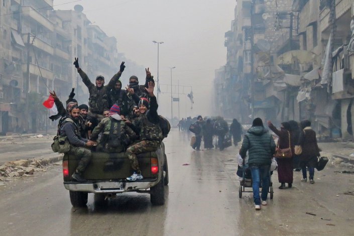  Tropas do Exército sírio atravessam o bairro libertado de Bustan al-Qasr em Alepo, no Norte da Síria (12 de Dezembro de 2016) / AFP 
