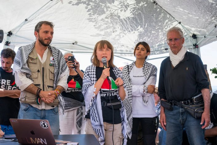 Greta Thunberg fala à impresa antes da partida do barco Madleen, da Flotilha da Liberdade, que tentou furar o cerco marítimo a Gaza, Palestina. Ao lado, o activista brasileiro Thiago Ávila e a eurodeputada francesa, de origem palestiniana, Rima Hassan, que continuam sequestrados em Israel, em regime de solitária. 