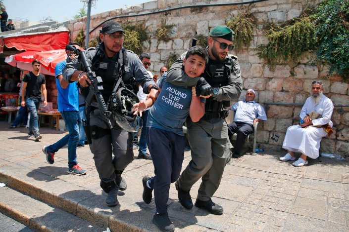 Guardas israelitas detêm um jovem palestiniano durante uma manifestação na entrada principal do complexo de mesquitas de Al-Aqsa. Jerusalém, Palestina, 17 de Julho de 2017