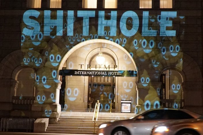 Projecto artístico multimédia «Try Our Shithole», no Trump International Hotel. A mensagem completa é «Not a DC resident? Need a place to stay? Try our shithole». Photo: @bellvisuals. «Shithole Projection on Trump Hotel», #Resist.
Para conhecer Robin Bell consultar http://bellvisuals.com/ e https://www.instagram.com/bellvisuals/.